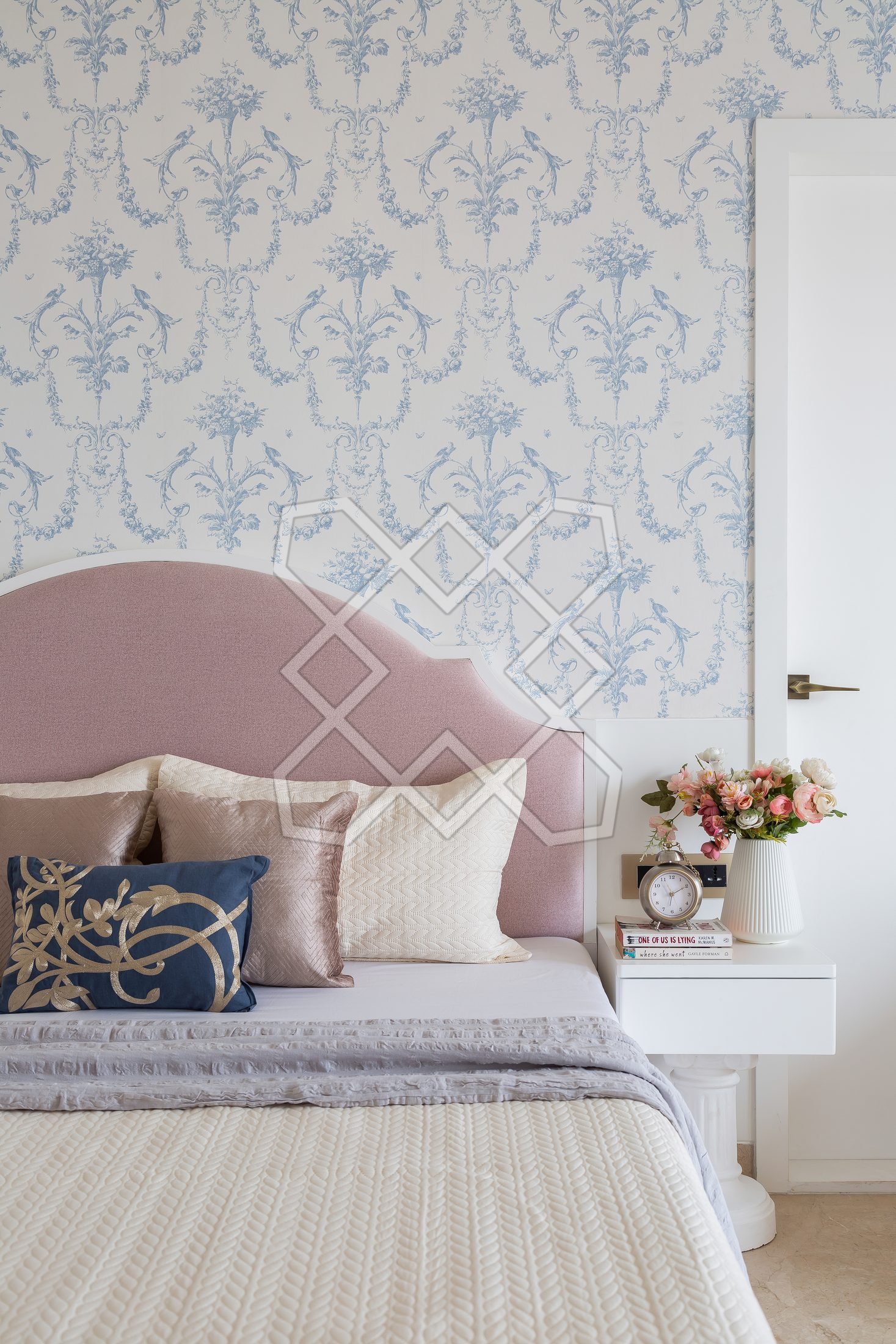 A bedroom at The Eternal Solace, with its imported damask wallpaper and arched blush headboard