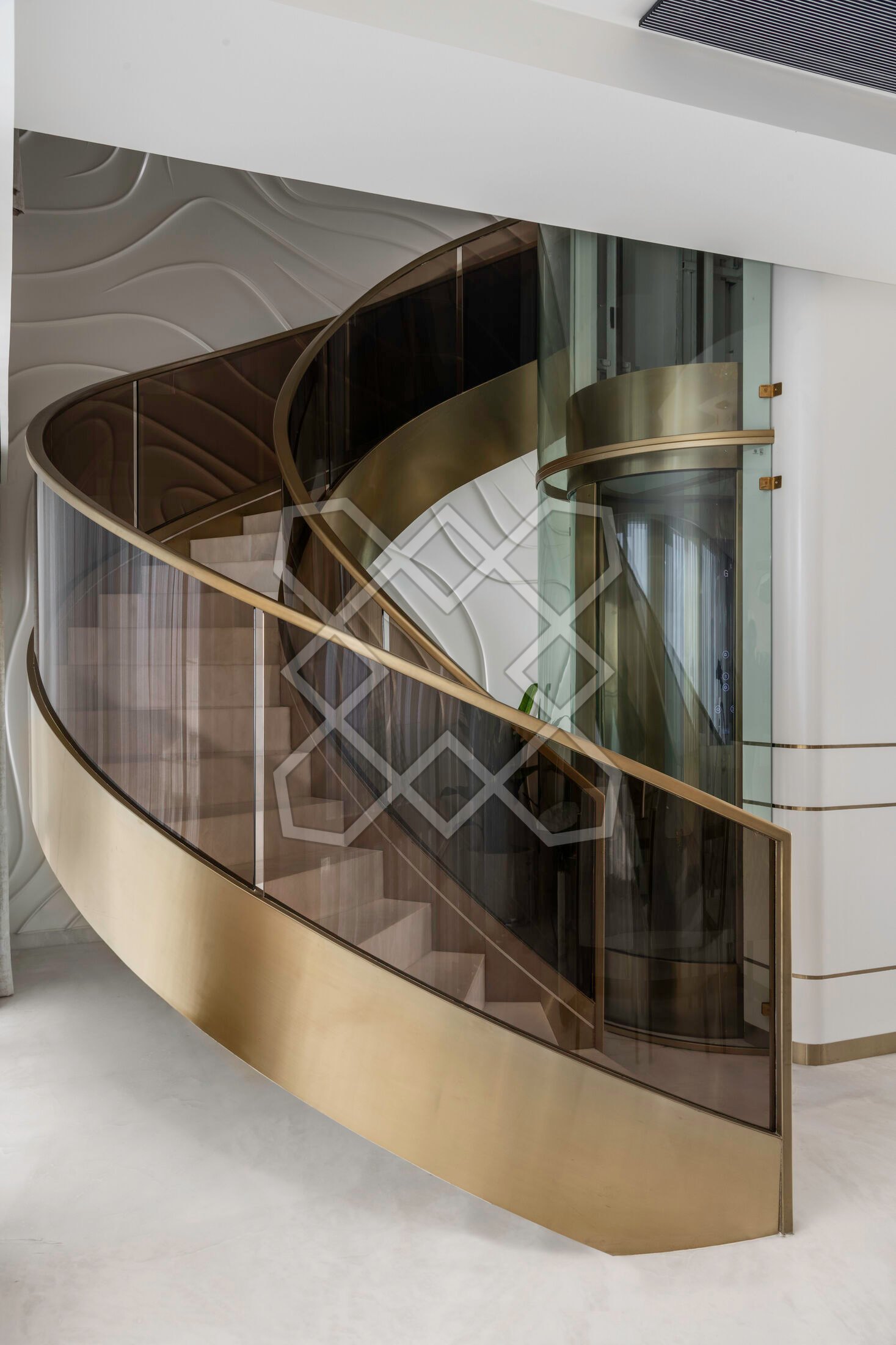The brushed brass handrail and ombré glass railing